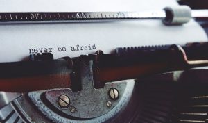 The words, "Never Be Afraid" typed on a typewriter in black ink.