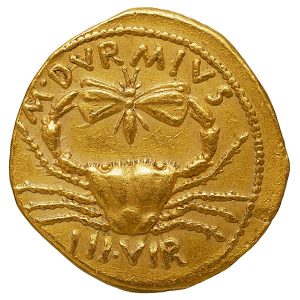 Photograph of gold coin with a crab and butterfly.