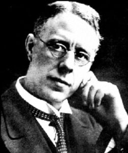 Black and white photograph of man with round glasses.