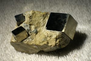 A photograph of pyrite with three primitive cubes.