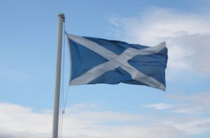 A white saltire on a blue background flag in the wind